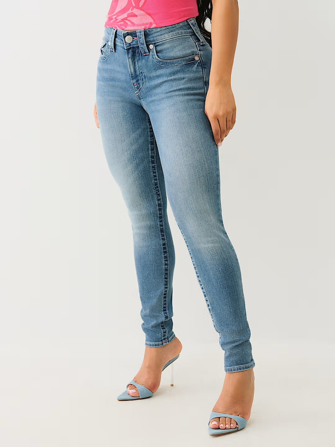 Jeans ajustados azul claro con lavado desgastado, modelo skinny para mujer, combinados con sandalias de tacón